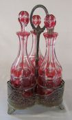 3 cranberry glass decanters in silver plated stand (1 decanter af) H 38 cm