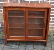 Pitch pine bookcase with glazed sliding doors