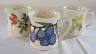 3 Moorcroft mugs (2 second quality) patterns inc rosehip and plum H 8.5 cm