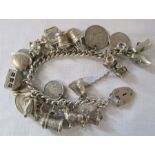 Silver charm bracelet with assorted charms and coins total weight 2.67 ozt