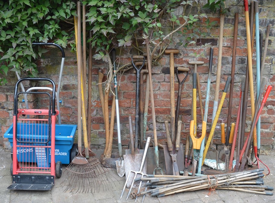 Large quantity of gardening tools, fertilizer spreader & a sack barrow
