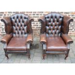Pair of brown leather button back armchairs (tear to arm)