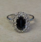 Tested as 18ct white gold sapphire and diamond cluster ring, sapphire 1.10 ct (9 mm x 5 mm)