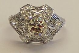 Tested as platinum vintage style diamond cluster ring set with central brilliant cut diamond