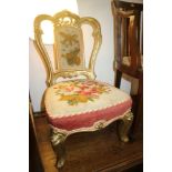 A late 19th century gilt framed low seat nursing chair with needlepoint seat and back, on cabriole