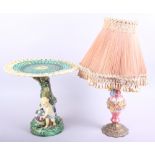 A Wedgwood majolica comport (damages) and a floral encrusted table lamp