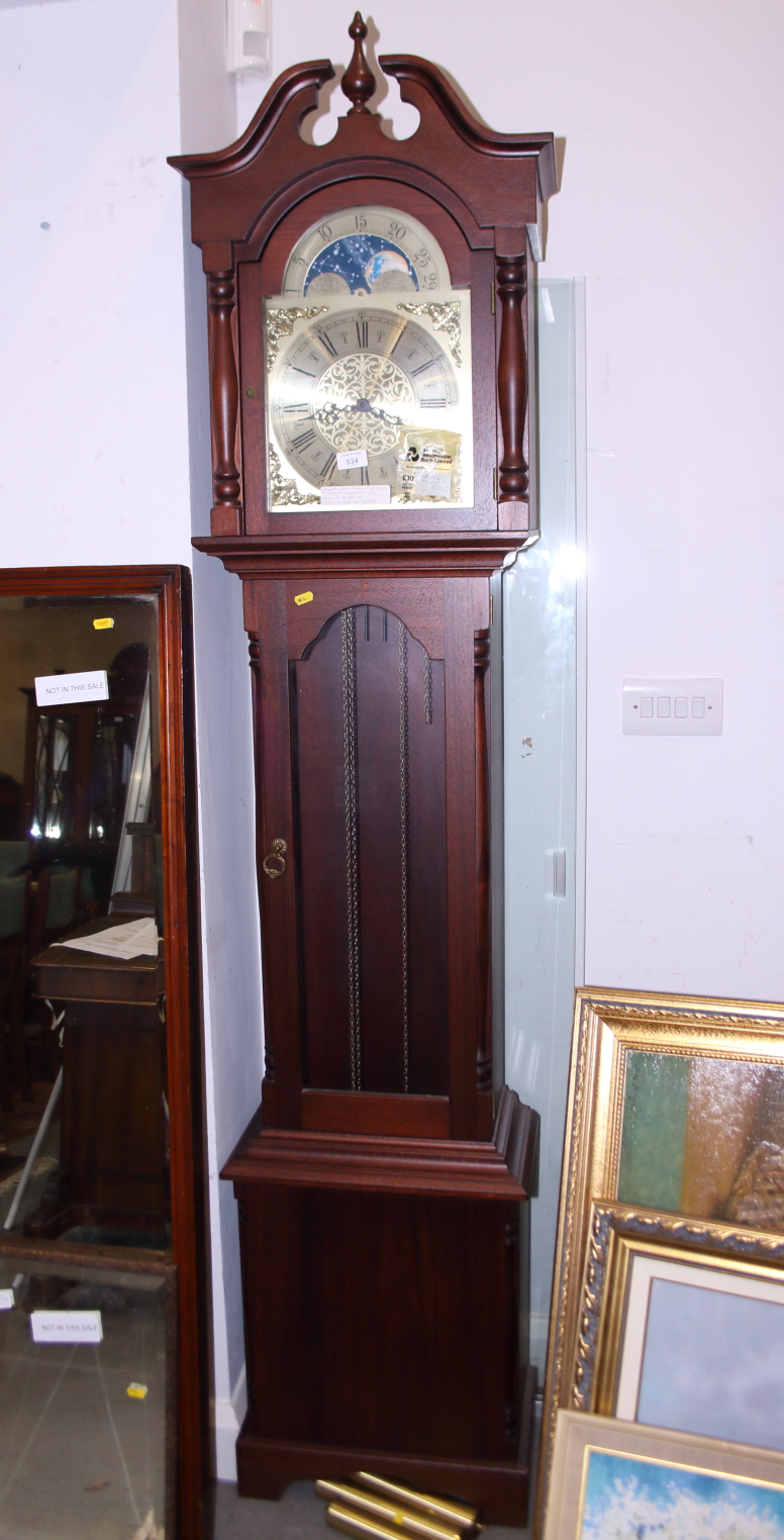 A mahogany long case clock with eight-day striking and chiming movement, arch top dial, 81" high