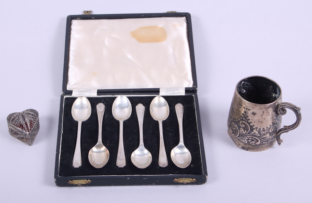 A silver christening mug with inscription, a cased set of six silver teaspoons, a white metal