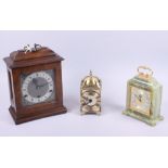 A mahogany cased mantel clock, an onyx cased mantel clock and a modern lantern clock