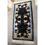 A Chinese wool and silk contour pile rug with flowers on a blue ground, 24" x 48" approx