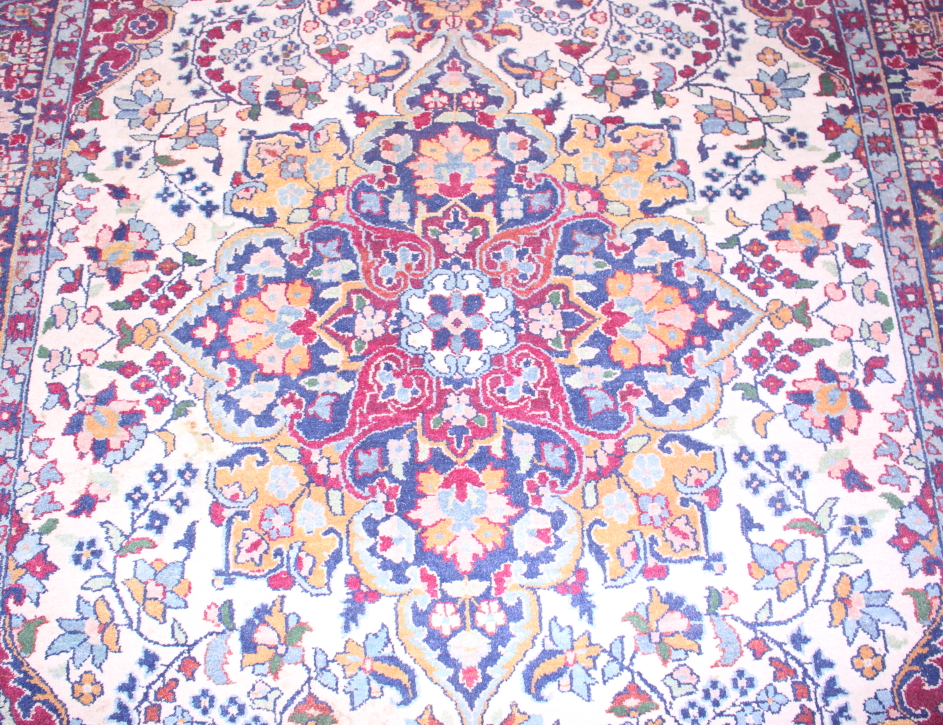 A Persian rug with central medallion and flower decoration in shades of red, blue, green and - Image 2 of 4