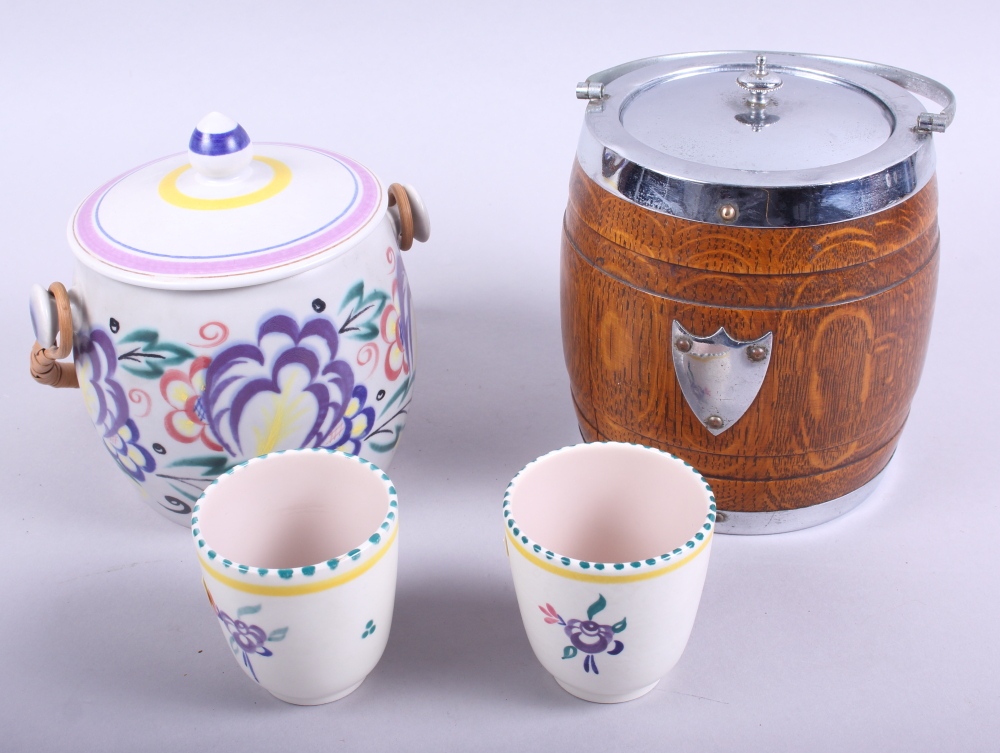 A Poole pottery biscuit barrel, two similar beakers, and an oak biscuit barrel with plated mounts