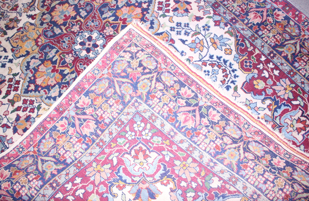 A Persian rug with central medallion and flower decoration in shades of red, blue, green and - Image 4 of 4