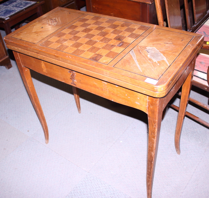 A 19th century polished as walnut fold-over top games table with inlaid decoration, on square