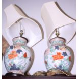 A pair of Chinese polychrome porcelain vases, now converted to table lamps, on turned wood bases,