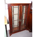 A polished as mahogany display bookcase, fitted glazed doors on reeded columns, on bracket feet, 39"