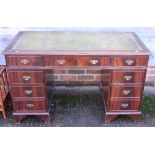 A mahogany kneehole double pedestal desk, fitted nine drawers with green leather tooled lined top,