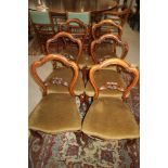 A set of six carved walnut loopback standard dining chairs with stuffed over seats, upholstered in a