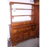 A pine kitchen dresser with three shelves above four drawers, over three drawers and three
