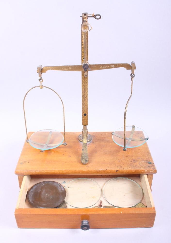 A set of brass balance scales, on wooden base, fitted one drawer