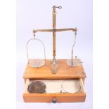 A set of brass balance scales, on wooden base, fitted one drawer