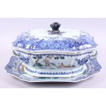 An 18th century blue, white and polychrome tureen, lid and stand, decorated flowers, figures and
