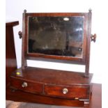 An early 19th century mahogany swing frame toilet mirror, on bowfront plateau base, fitted two