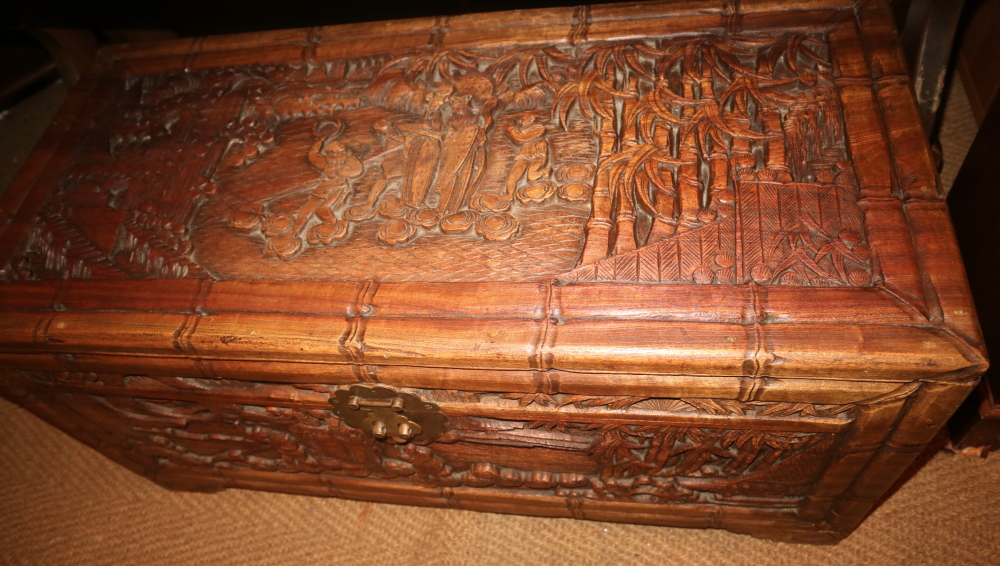 A Chinese carved camphor wood coffer with lift out tray, on bracket feet, 37" wide