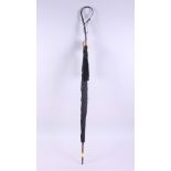 A lady's Edwardian black umbrella with hammered silver handle, formed as a swan's neck and head