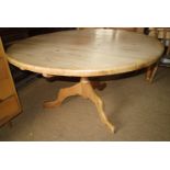 A waxed pine circular top dining table, on turned column and tripod splay supports, 60" dia