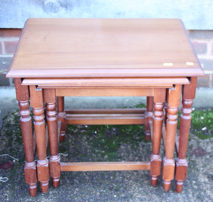 A nest of three walnut occasional tables, on turned and stretchered supports, largest table, 21"