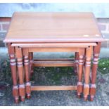 A nest of three walnut occasional tables, on turned and stretchered supports, largest table, 21"