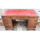 A mahogany double pedestal desk with red leather tooled lined top over nine drawers, on bracket
