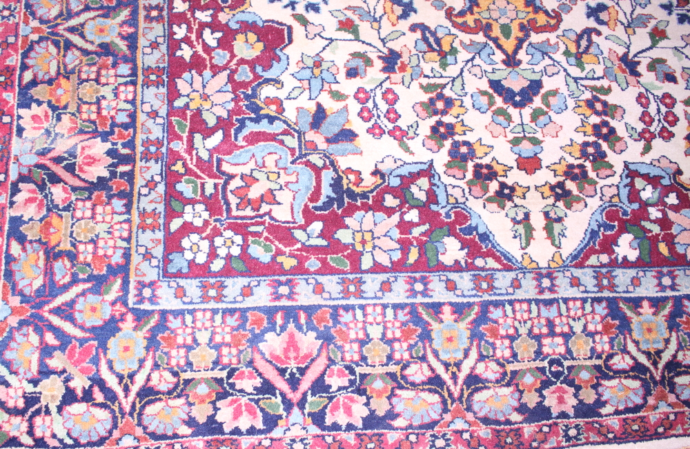 A Persian rug with central medallion and flower decoration in shades of red, blue, green and - Image 3 of 4