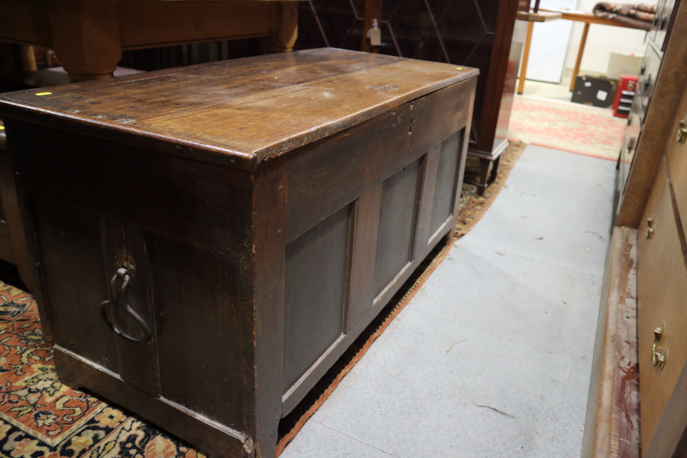 An 18th century oak coffer with candle box and wrought iron carry handles, on stile supports, 46 1/