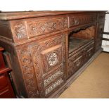 A 19th century Breton carved walnut sideboard, fitted three drawers over central recess and