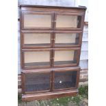 A Minty dark oak four-section bookcase enclosed glazed doors, 35" wide