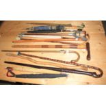 A selection of walking sticks, some with silver mounts, a shooting stick and a number of umbrellas