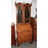 A walnut double dome top bureau bookcase enclosed mirrored doors, fitted one false drawer and