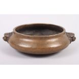 A Chinese bronze censer with masked handles, seal mark to base, 8 1/2" dia
