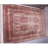 An Indian rug decorated four central gulls on a dark ground with multi-boarded in shades of green,