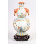 A Chinese Republic period polychrome enamel double gourd vase, with masked handles, decorated panels