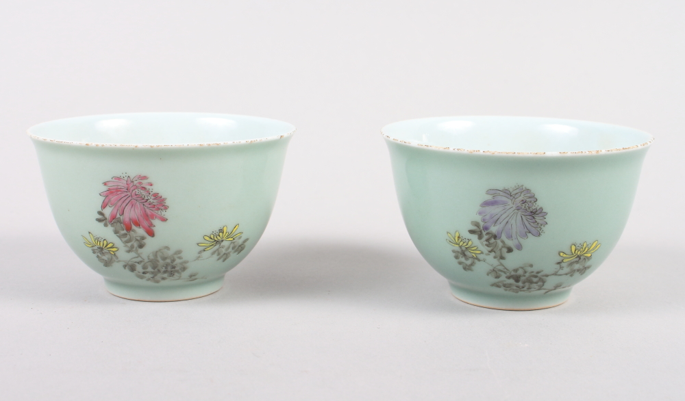 A pair of Chinese celadon glazed tea bowls with chrysanthemum and character decoration, seal marks