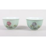 A pair of Chinese celadon glazed tea bowls with chrysanthemum and character decoration, seal marks