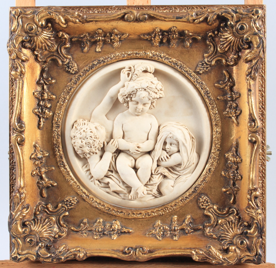 Two mounted plaques of three cherubs, in ornate gilt frames, 11 1/4" wide