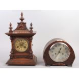 An oak cased mantel clock with finials and carved decoration, Roman numerals and an enamel dial, 17"