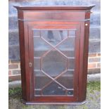 A mahogany corner display cabinet with two shelves enclosed glazed door, 26 1/2" wide