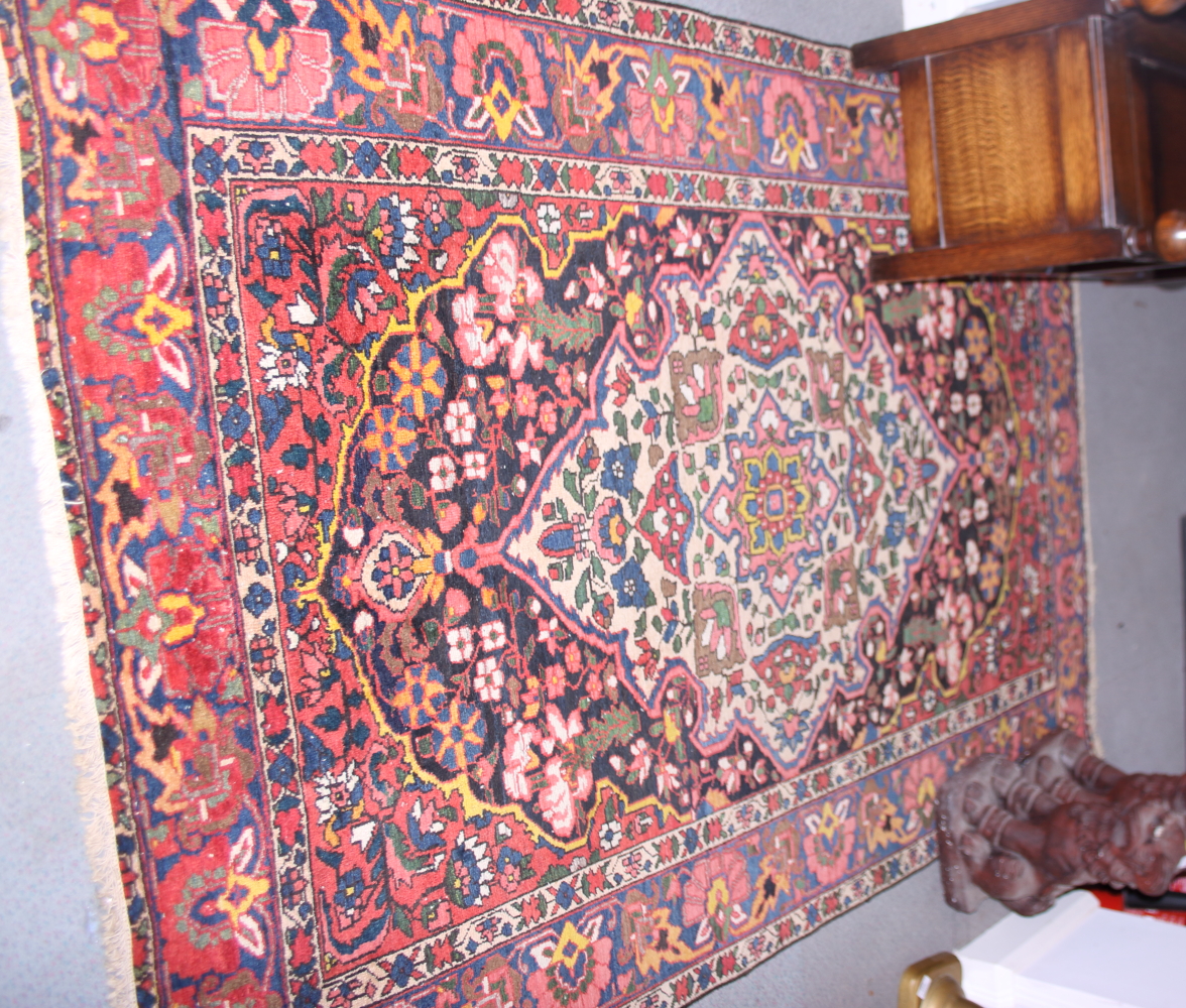 A Persian design rug decorated birds and flowers on a blue ground, 82" x 57" approx