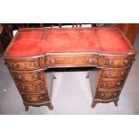 A mahogany shape front double pedestal desk with tooled red leather top, fitted nine drawers, on