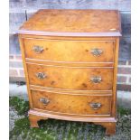 A walnut bedside chest of three graduated drawers, on bracket feet, 21" wide, two walnut shape top